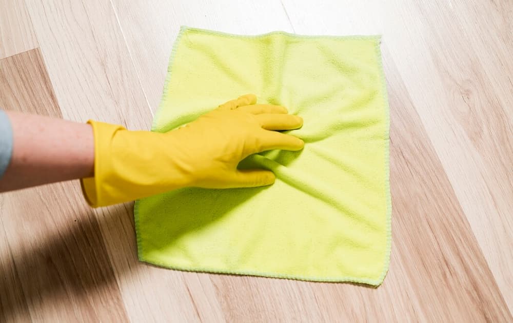 Mulher limpando o chão com pano